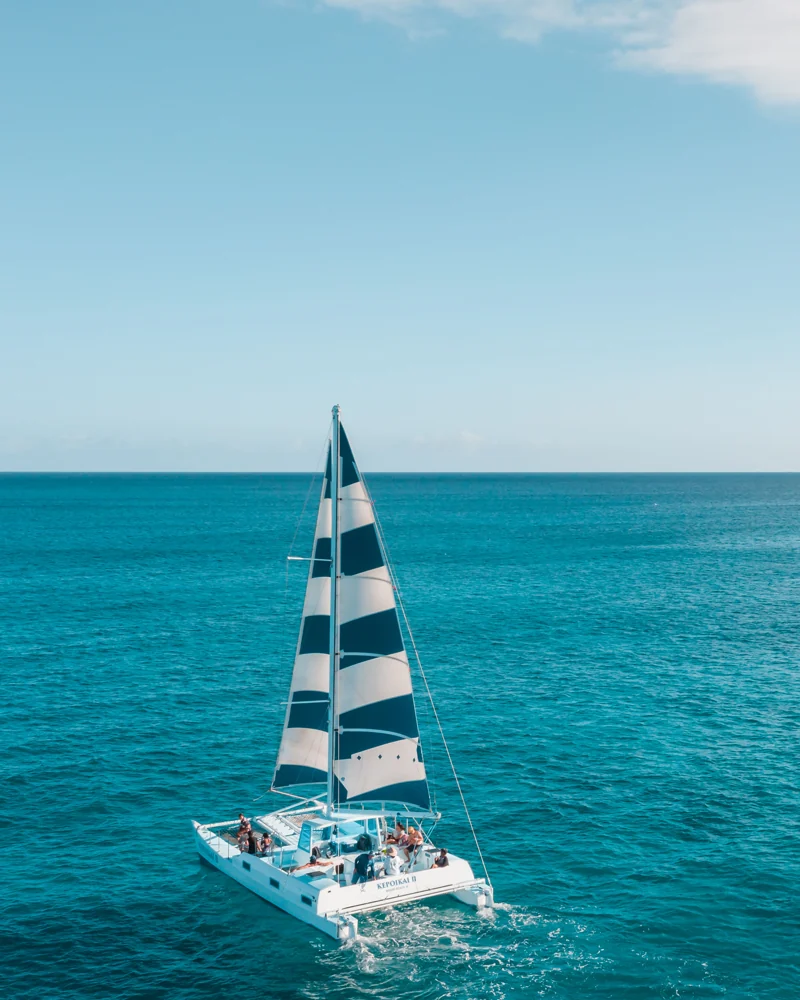 A white catamaran sailing on turquoise water